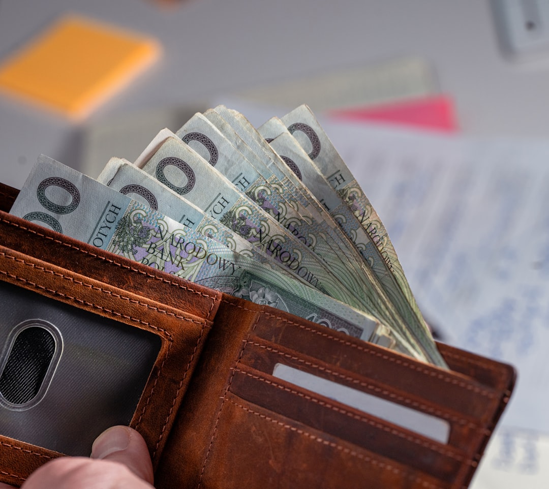 Brown leather wallet stuffed with polish currency.